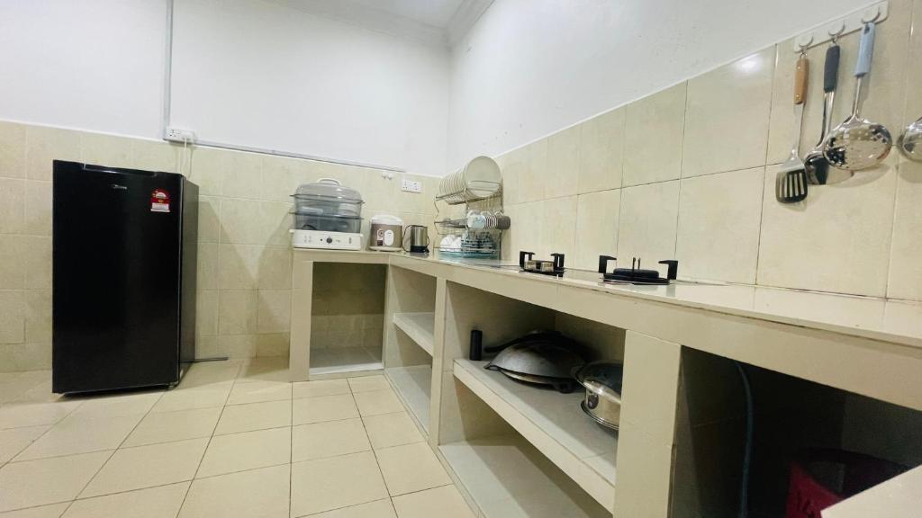 a kitchen with a black refrigerator in a room at Sporting Homestay in Semporna