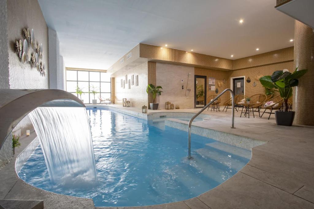 a swimming pool with a waterfall in a building at Eden Hotel & Spa in Cannes