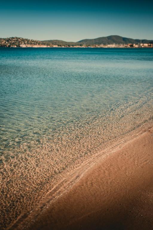 Blick auf den Strand mit dem Wasser in der Unterkunft Les Prairies de la Mer in Grimaud