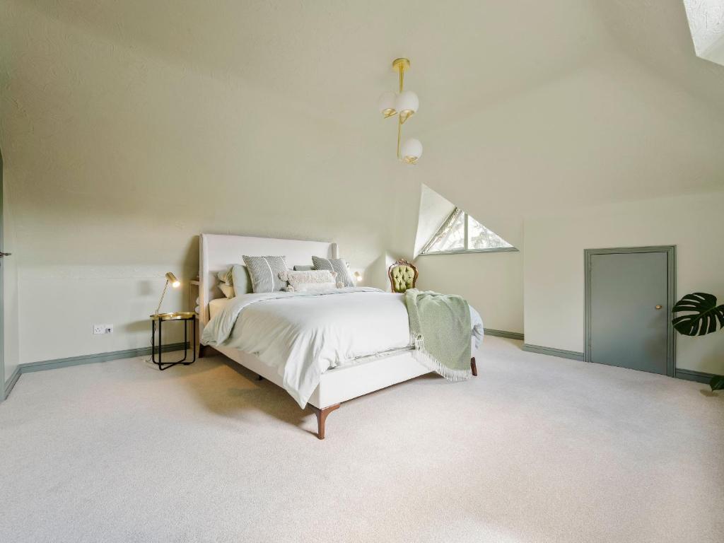 a white bedroom with a large bed and a window at The Loft - A Stylish Holiday Property in Weymouth with Sea View and Parking in Weymouth