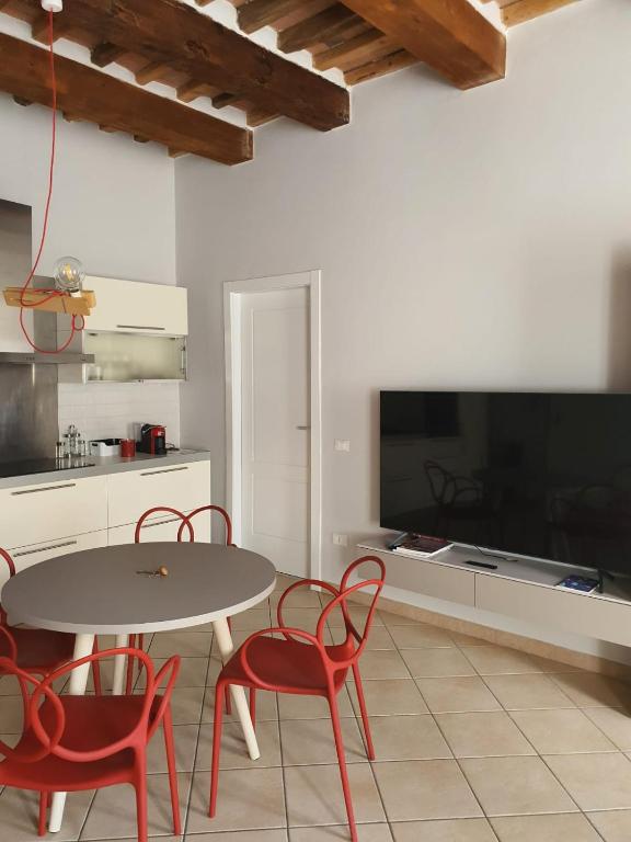 Una cocina con mesa y sillas y un televisor. en Mossotti Street Apartment, en Pisa
