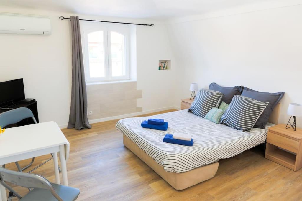 un salon avec un canapé avec deux plats bleus dessus dans l'établissement #36 Studio liberté, 5 minutes de la plage/AC, à Nice