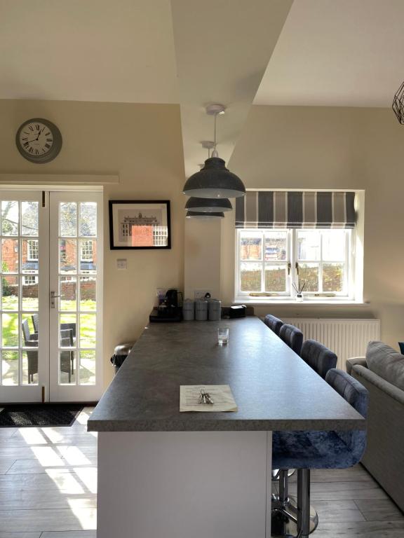 a kitchen and living room with a large table at STABLE COTTAGE in Cheswardine