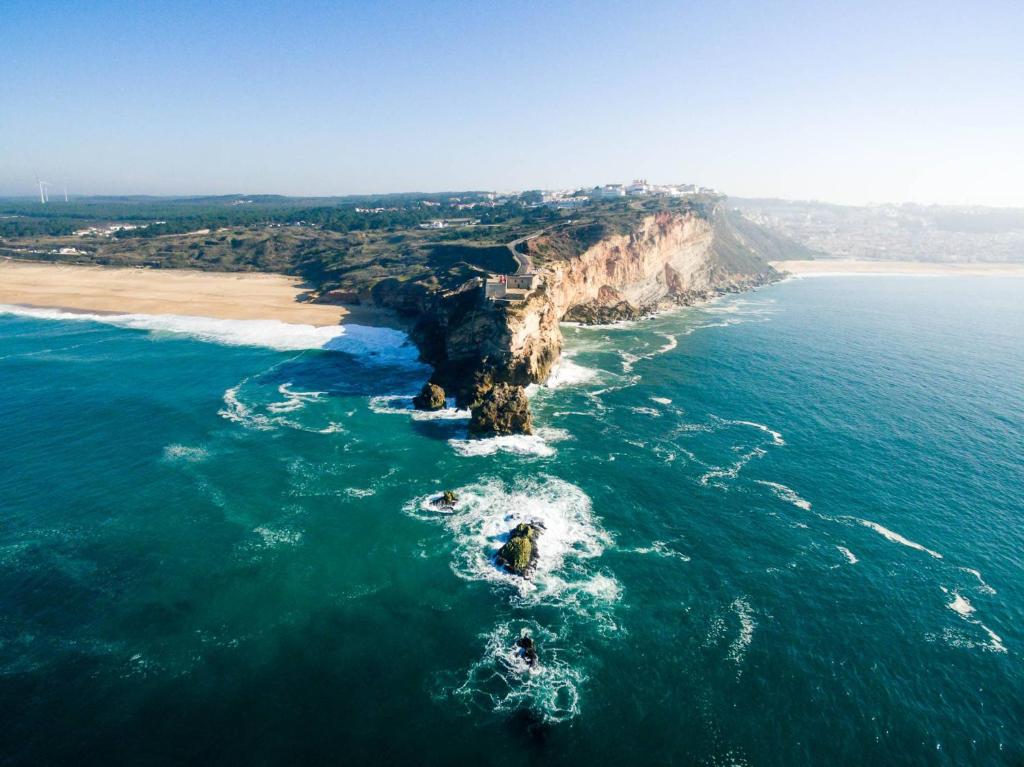 an aerial view of a cliff in the ocean at Ricky House Big Waves in Nazaré