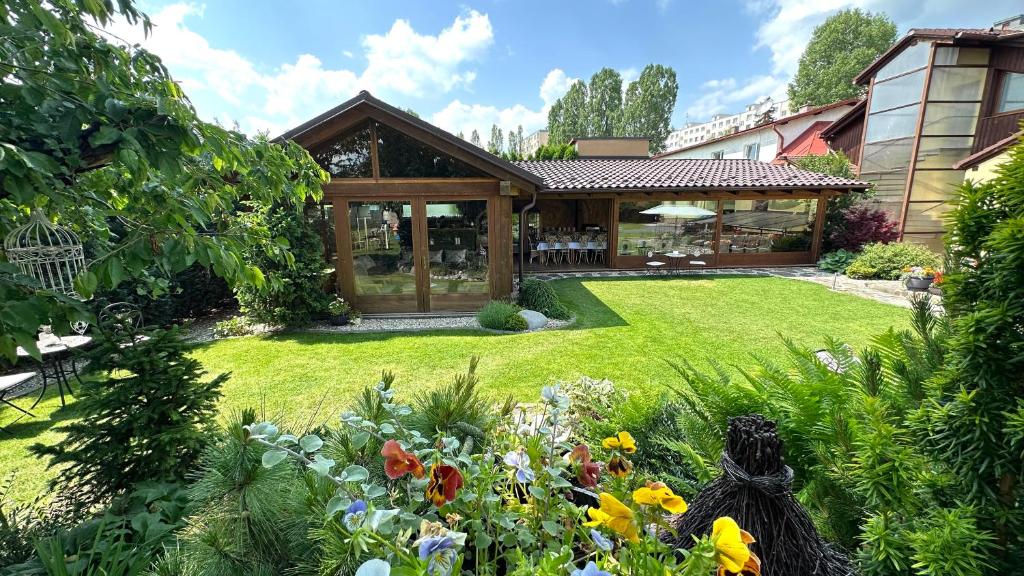 una casa con un jardín con flores en el patio en Wellness Penzión Vila Mery en Poprad