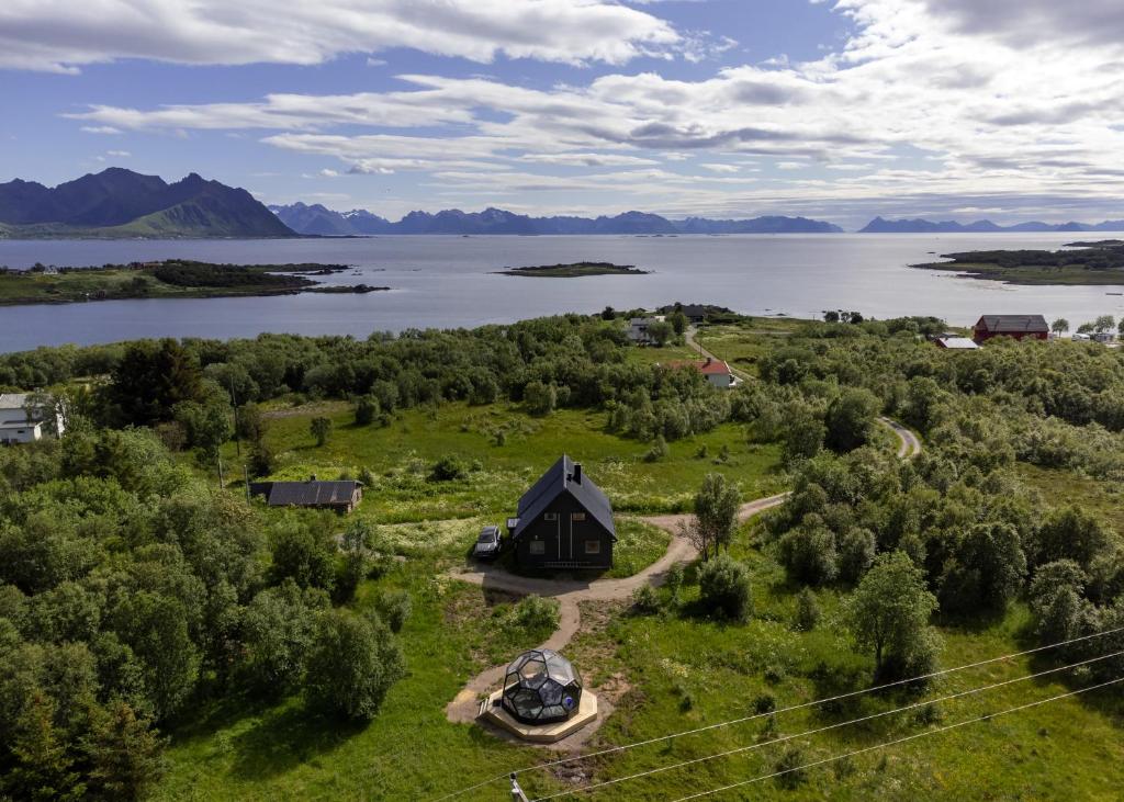 an aerial view of a house on the shore of a lake at Bestefarhaugen - The cozy house on the hill - with a dome in Bø