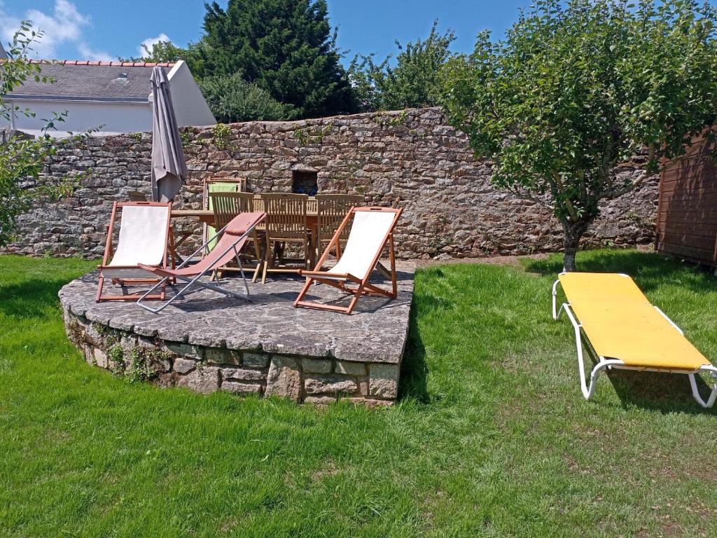 a group of chairs and a table in a yard at La maison de Jeanne in Pont-Croix