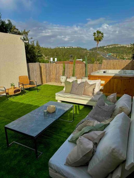 un patio con sofás y una mesa en un patio en ירוק במושב, en Ma‘oz Ẕiyyon