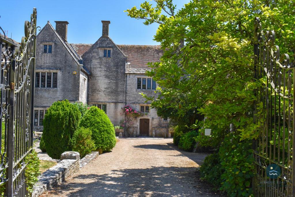 Poxwell Manor West Wing - Exclusive Dorset Retreat : مدخل لبيت حجري قديم مع بوابة