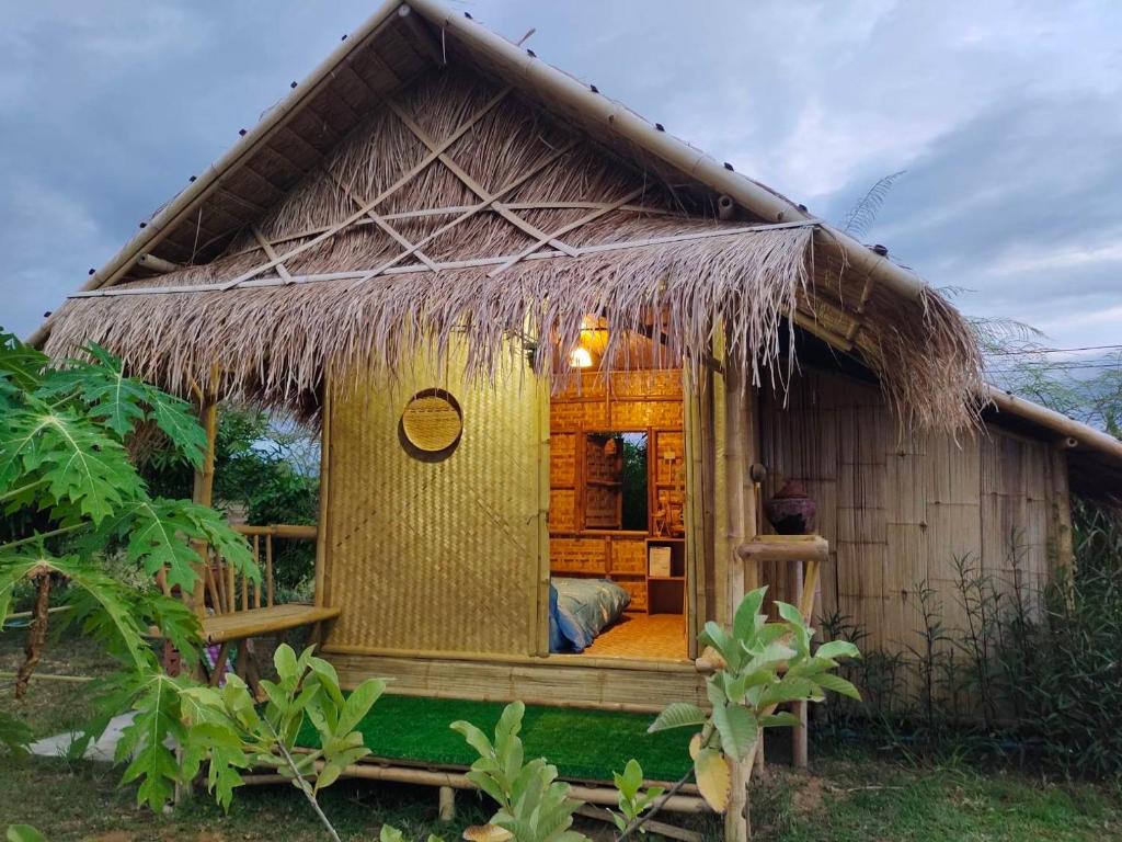 ein kleines Haus mit einem Strohdach in der Unterkunft บ้านสวนกางโต้ง Ban Suan Kang Tong in Chom Thong