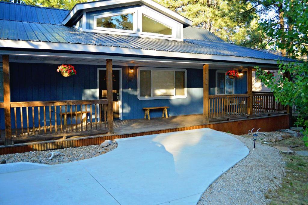een blauw huis met een veranda en een oprit bij 210 Forest Ridge Drive in Durango
