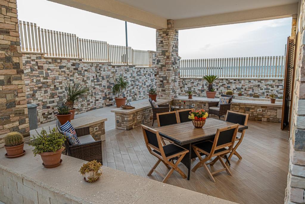 un patio al aire libre con mesas, sillas y plantas en Villa Panorama sul Mare, en Balestrate