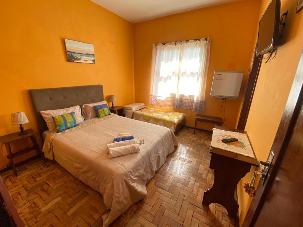 a bedroom with a large bed and a window at Hotel Philipp in Teresópolis