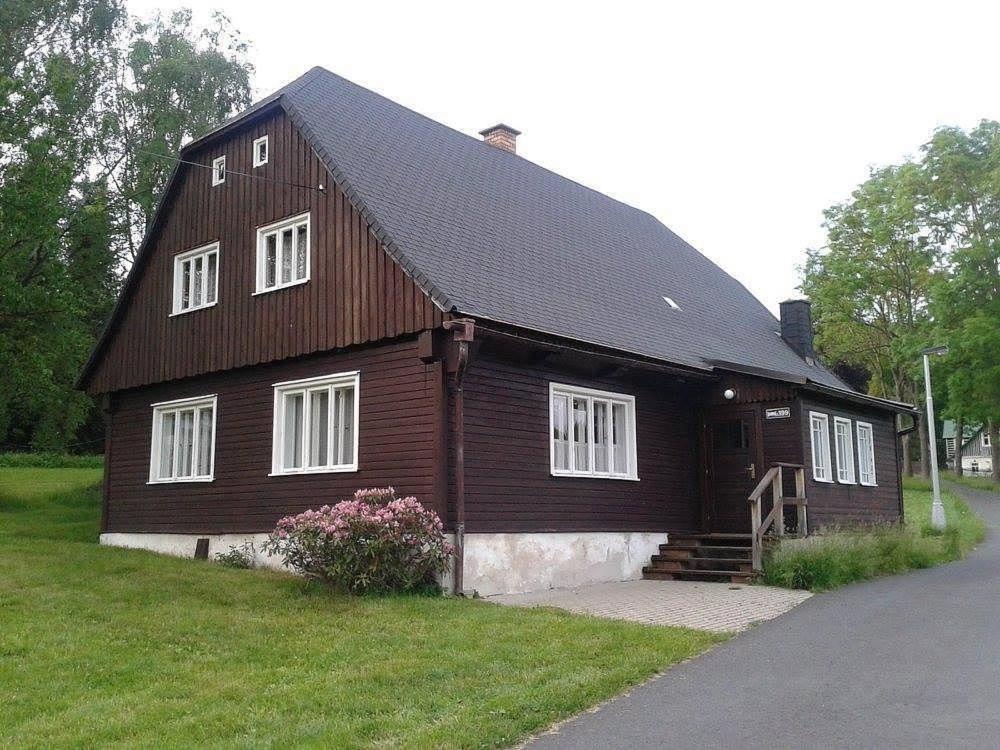 ein großes Holzhaus mit schwarzem Dach in der Unterkunft Chata Čeřovský Harrachov in Harrachov