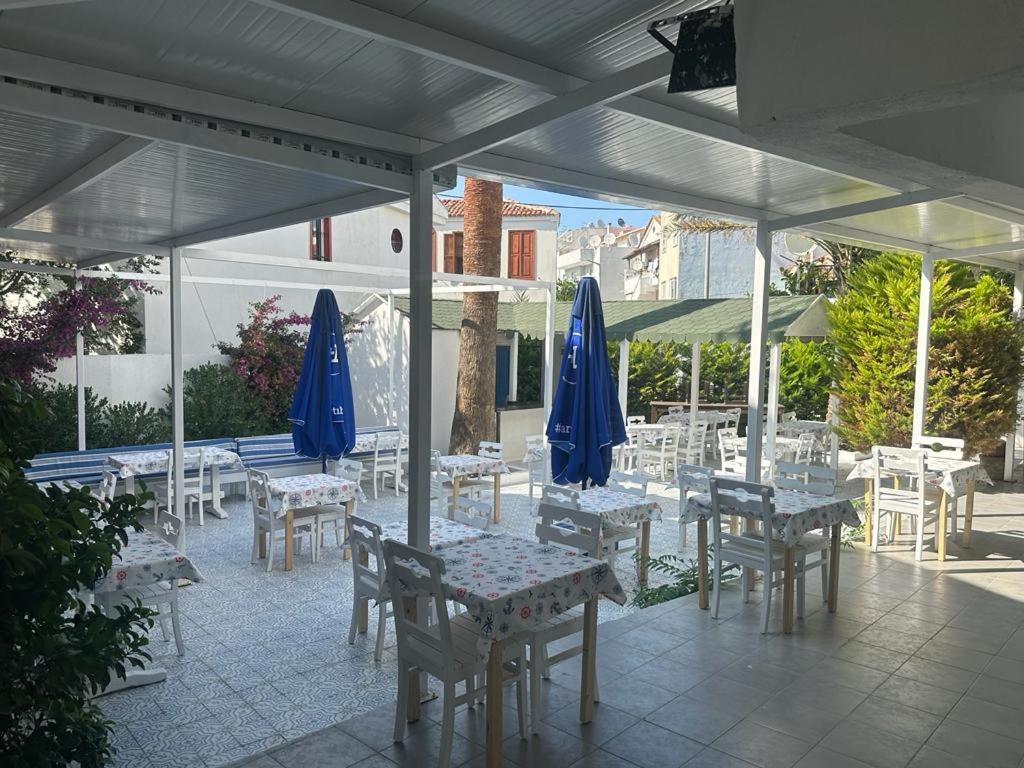 a patio with tables and chairs with blue umbrellas at OTEL A in Çeşme