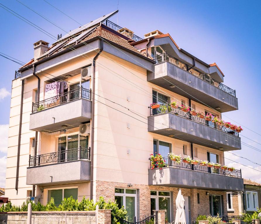 an apartment building with balconies and flowers on it at Bogdanovi Guest House in Chernomorets