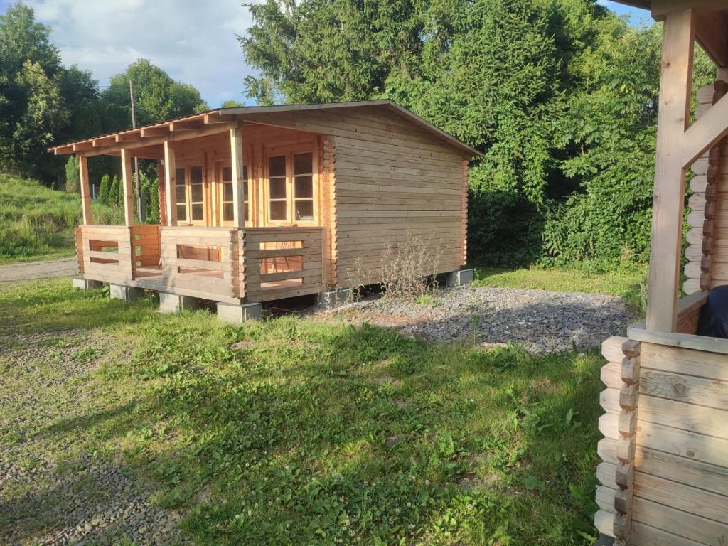 une cabane en bois dans une cour à côté d'une maison dans l'établissement Nový kemp Slezské Pavlovice, à Slezské Pavlovice