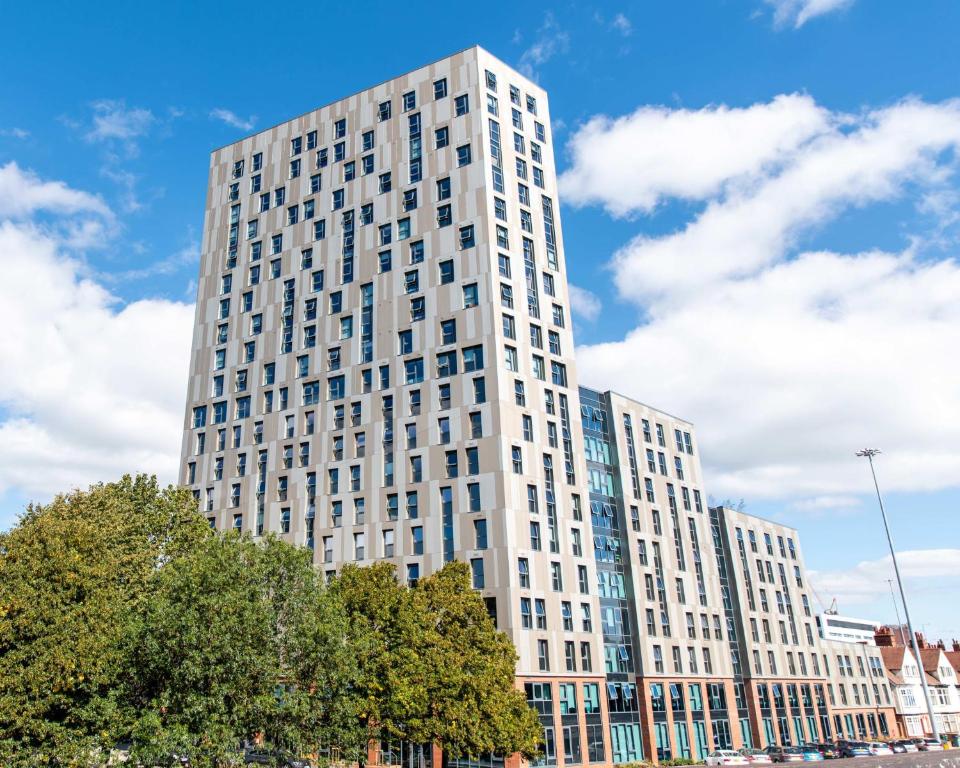 a tall white building with trees in front of it at Modern Ensuites with Shared Kitchen at Trinity View Student Accommodation in Coventry for Students Only in Coventry