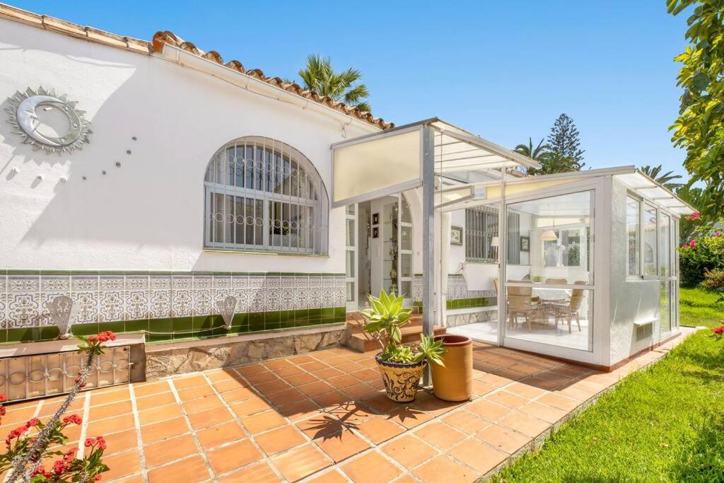 a white house with a glass door and a patio at Casita Sevilla in Mijas Costa