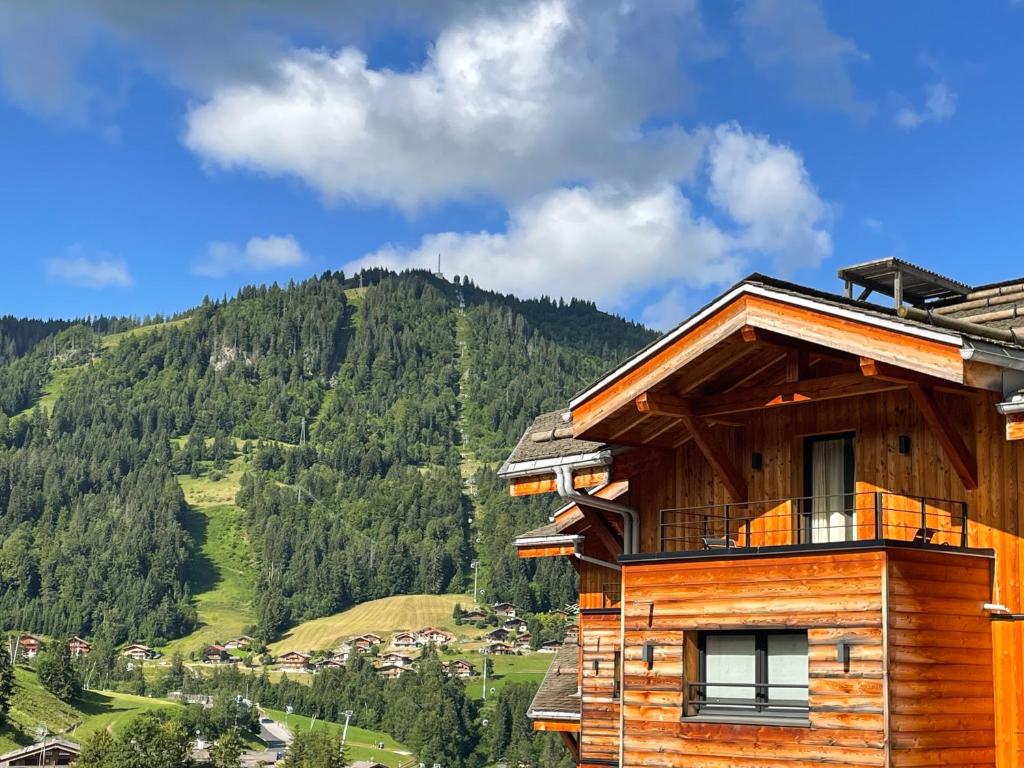 um chalé de madeira com vista para uma montanha em St-Alban Hotel & Spa em La Clusaz