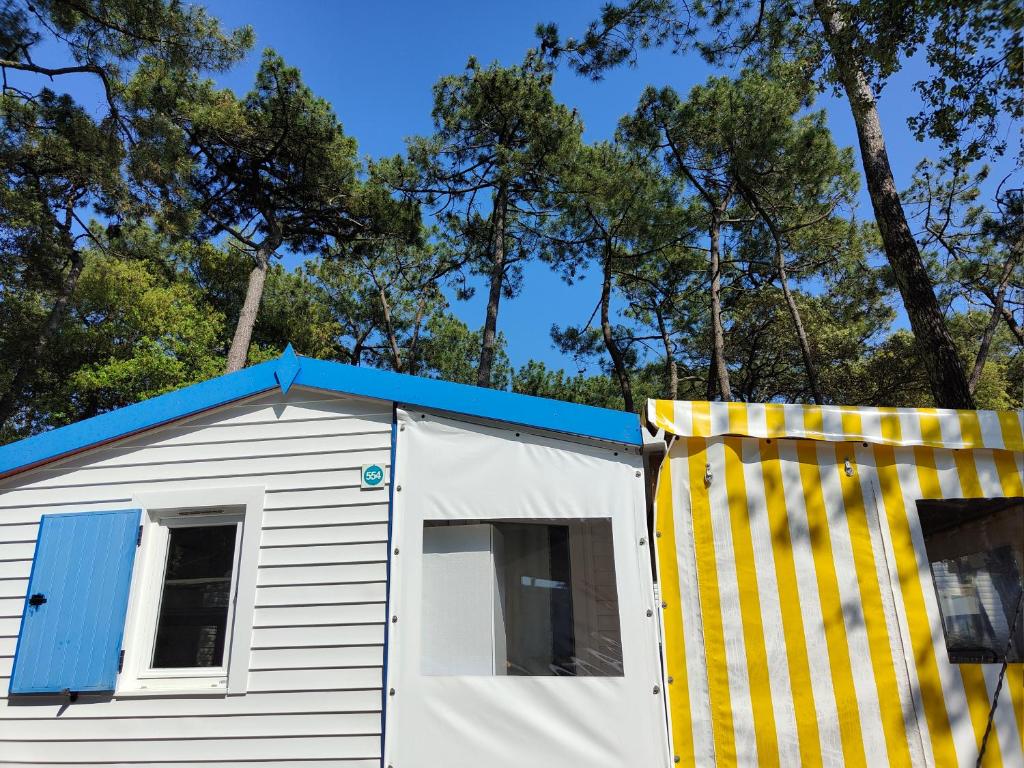 un hangar blanc et bleu avec un toit bleu dans l'établissement Bungalow cosy à 300m de l’océan, à Bretignolles-sur-Mer
