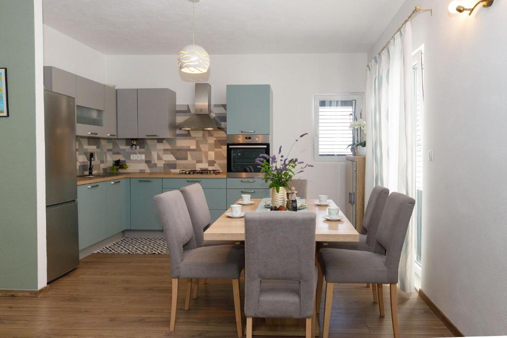 cocina con mesa de comedor y sillas en Blue home en Makarska