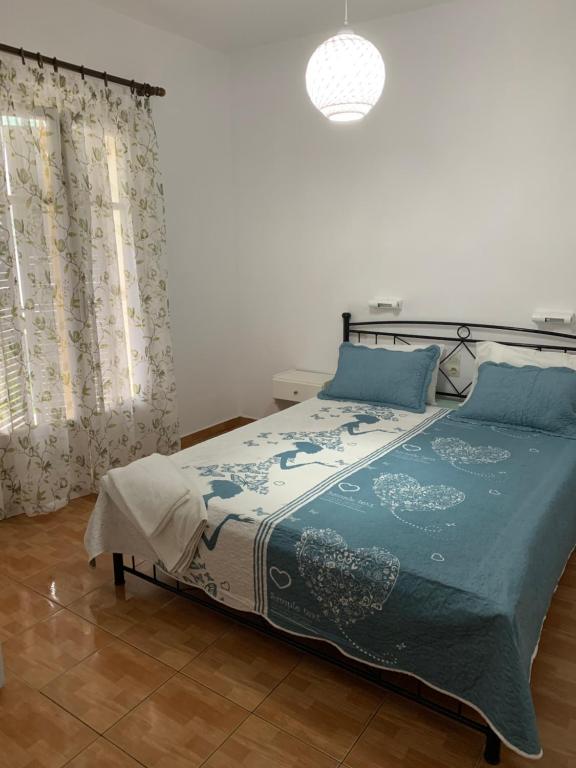 a bedroom with a bed with a blue comforter at ΜΕΤΑΧΑ in Mikros Gialos