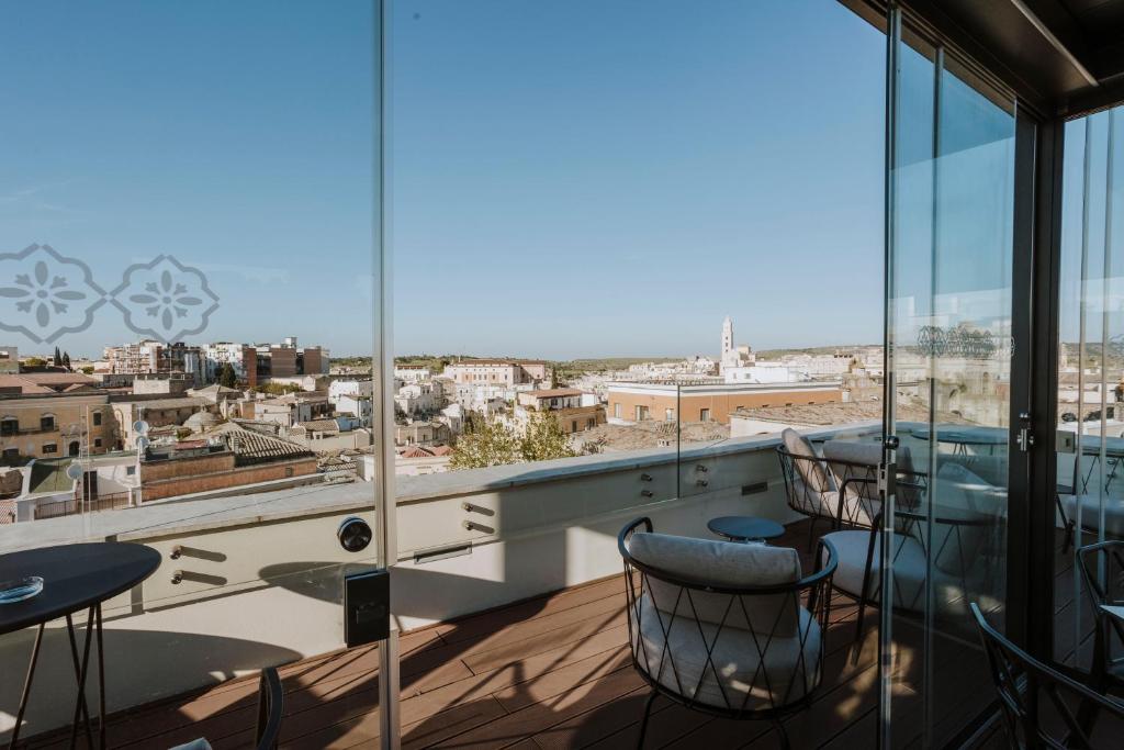 a balcony with tables and chairs and a view of the city at Palazzo della Fontana in Matera