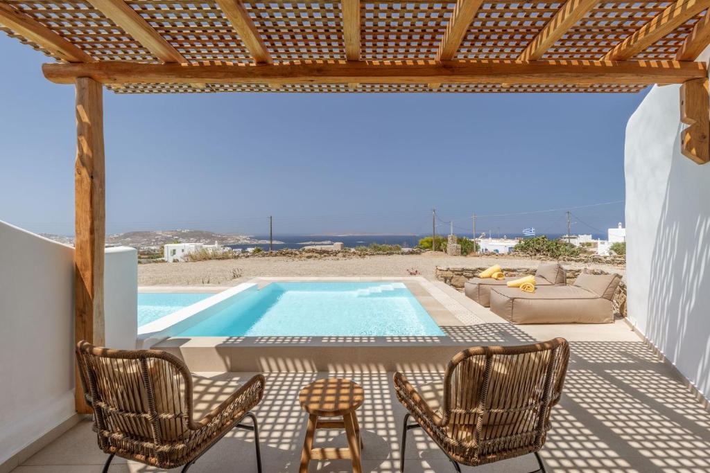 a patio with chairs and a swimming pool at Aya Sofia Suites in Mikonos