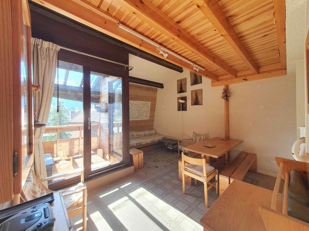 a living room with a table and a large window at Duplex 6 personnes, VARS LES CLAUX, Skis aux pieds in Vars