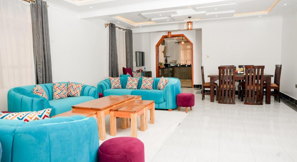a living room with blue chairs and a table at Advent Homes on Moi South lake road, Villa View Estate in Naivasha