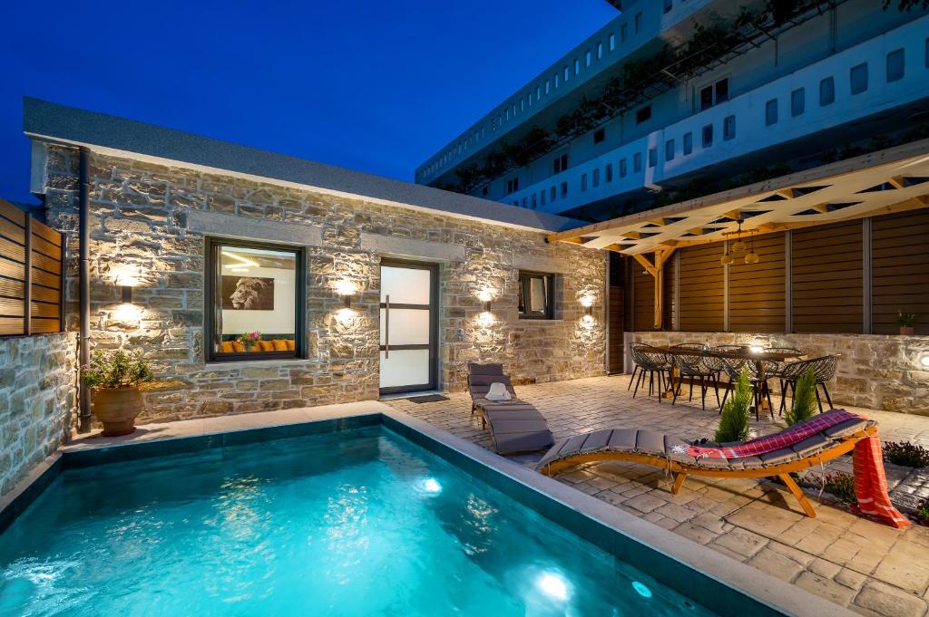 una piscina frente a una casa con patio en Villa Privilege Kalamaki en Kalamaki
