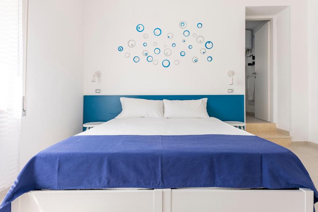 a bedroom with a blue and white bed and a clock at Dimora Terra di Puglia in Torre Santa Sabina