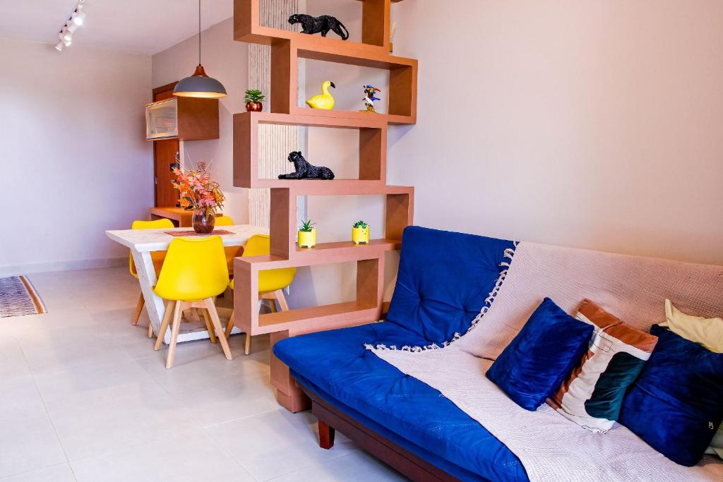 a living room with a blue couch and a table at Apartamento sofisticado, confortável e bem equipado - Loft Felau in Cuiabá