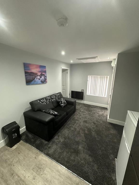 a living room with a black couch in a room at Royal Apartments in Thornaby on Tees