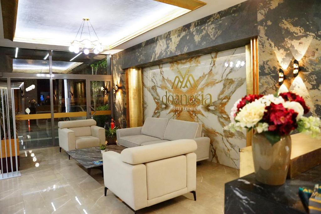 a lobby with couches and flowers on a wall at Doanesia Premium Hotel & Spa in Tirana