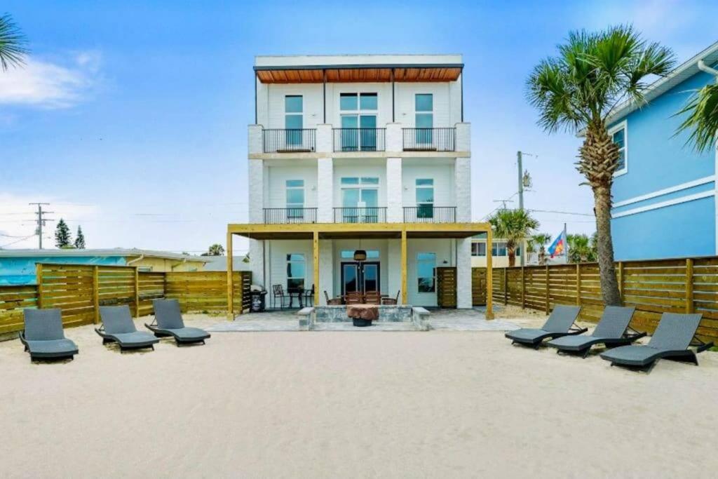 a group of lounge chairs in front of a building at Stairway to Heaven Hot Tub Beach Retreat in Flagler Beach