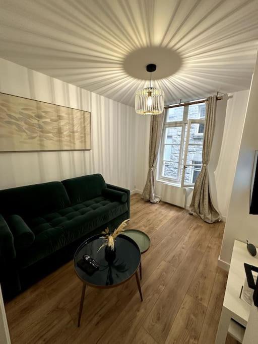 un salon avec un canapé vert et une table dans l'établissement Appartement St-Malo Intramuros, à Saint-Malo