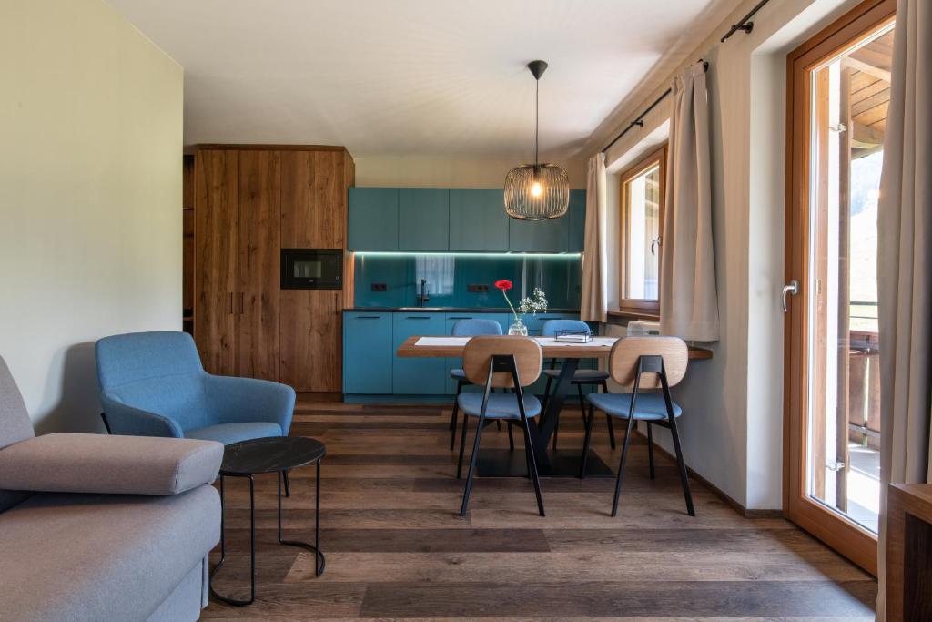 cocina y sala de estar con mesa y sillas en Apartments Karbon, en Castelrotto