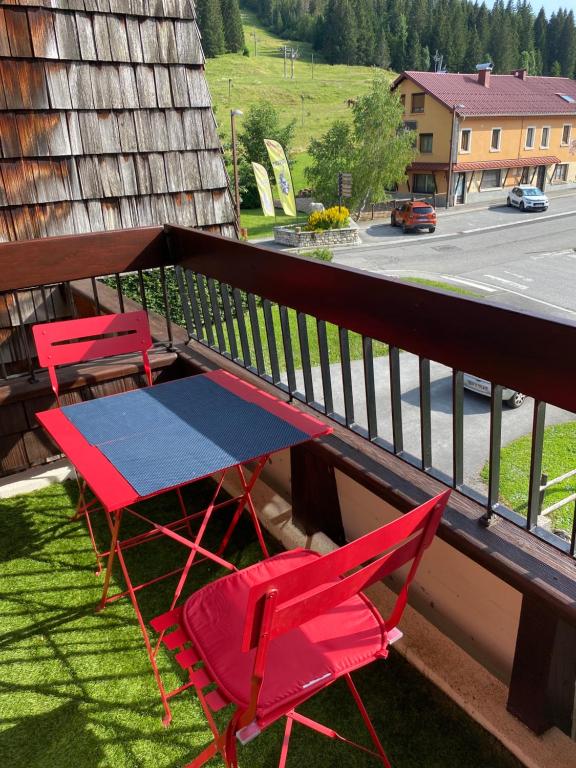 three chairs and a table on a balcony at APPARTEMENT DE MONTAGNE in Mijoux