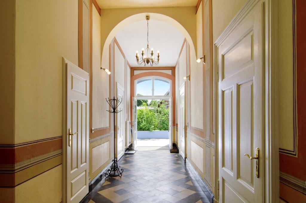 a hallway with an arched door and a chandelier at Villa Fokken Kapitänsquartier in Esens