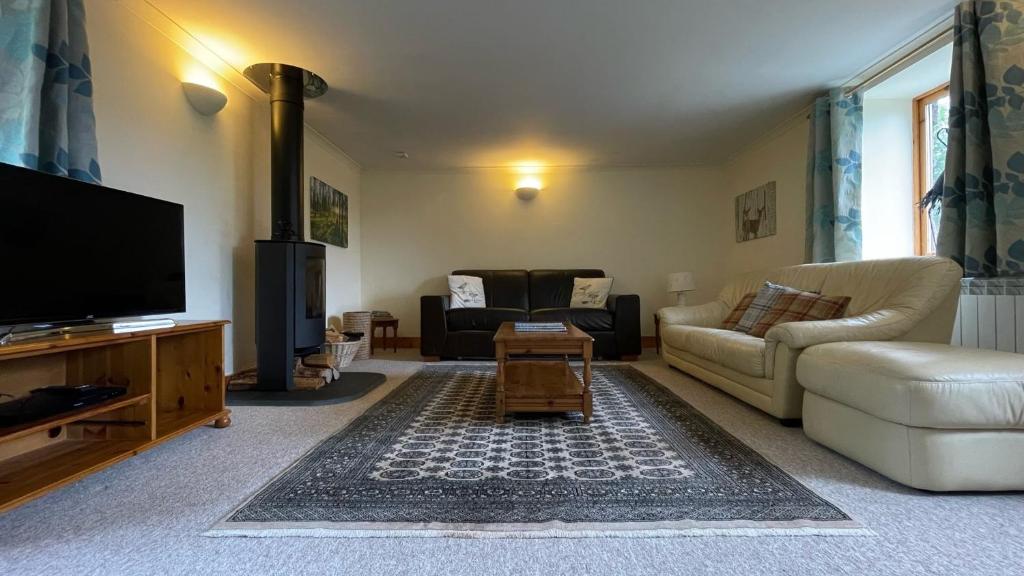 a living room with a couch and a tv at Kerrowdown Cottage-Self Catering for 4 in the Highlands in Drumnadrochit