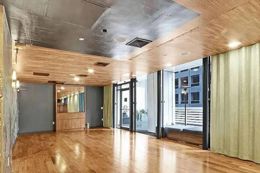 una stanza vuota con pavimento e finestre in legno massiccio. di Beautiful 2BD near Times Square with Doorman and Gym a New York