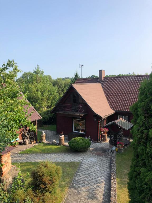 a house with a person standing in front of it at Sodyba prie akmenų in Leipalingis