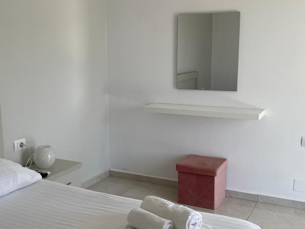 a white bedroom with a bed and a mirror at Villa Angelina Ksamil in Ksamil