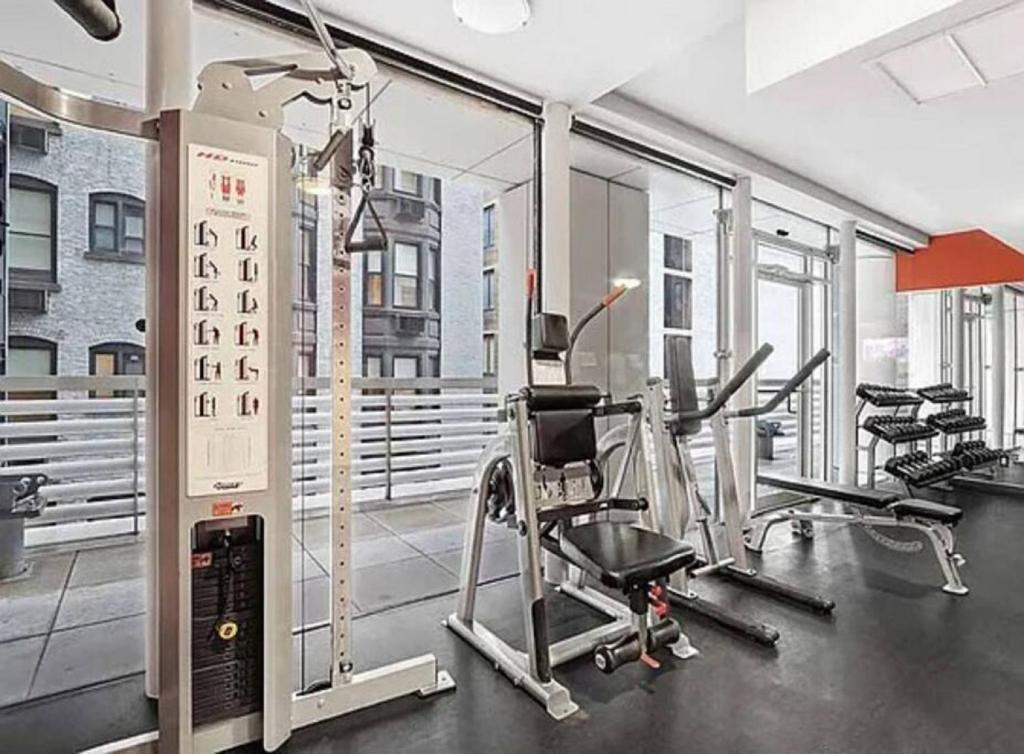a gym with treadmills and ellipticals in a building at Cozy 2BD near Times Square with Doorman and Gym in New York