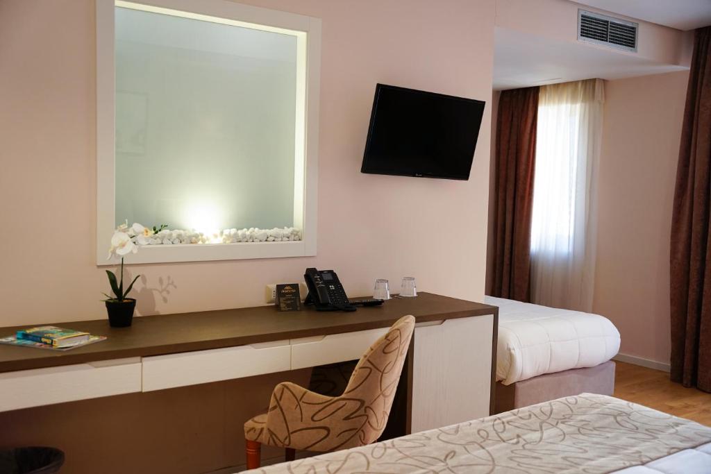 a hotel room with a desk and a bed at Doanesia Premium Hotel & Spa in Tirana