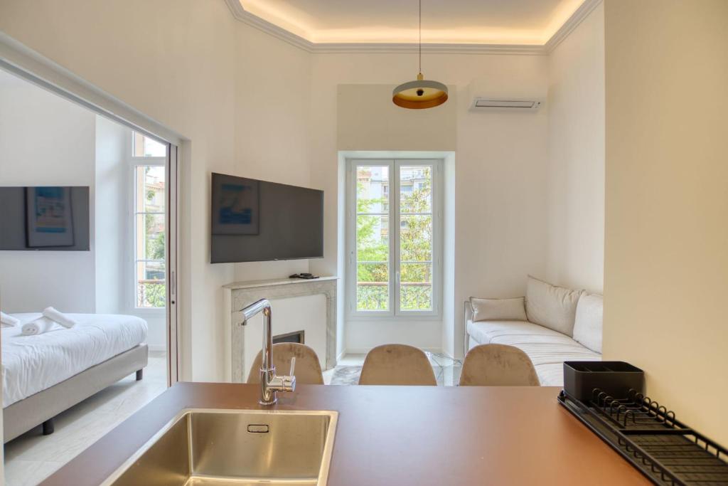 a kitchen with a sink and a living room at LimeSTAY - The Cannois T2 Modern WIFI in Cannes