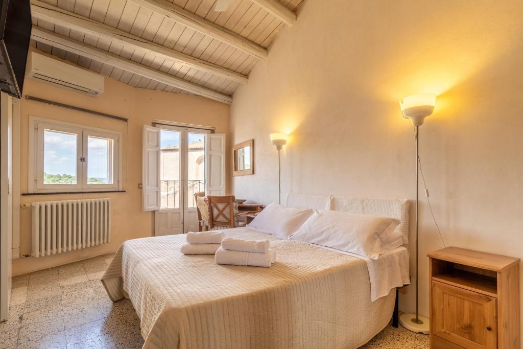 a bedroom with a bed with two towels on it at Caelum Hyblae in Ragusa