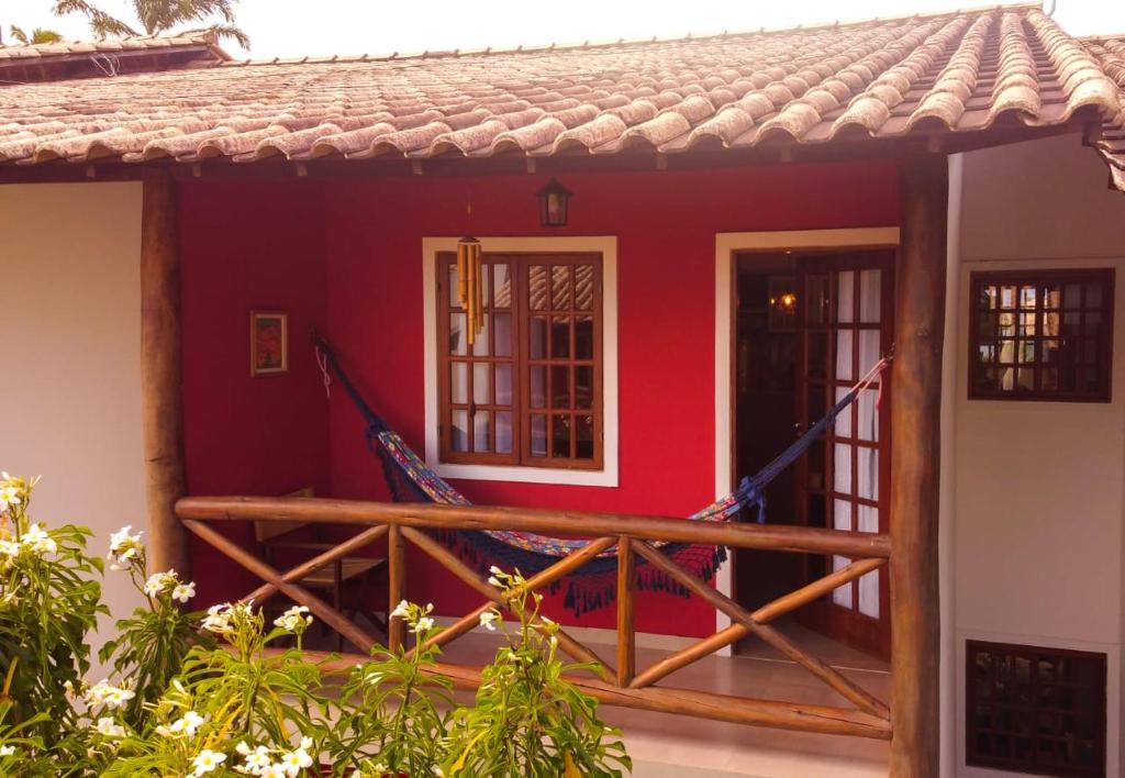 a small red house with a wooden deck at Apartamento Vivendas do Serrano in Lençóis